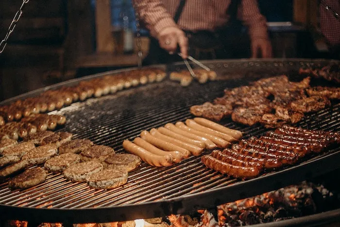 Sausages and meat patty on a barbeque grill image